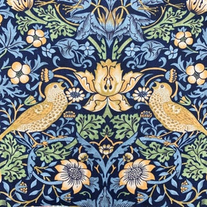 May include: Close-up of a fabric with a repeating pattern of birds, flowers, and foliage. The design features tan birds, yellow flowers, and green leaves against a navy blue background. The floral pattern includes stylized blooms and intricate details.
