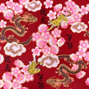 Op de afbeelding: Rode stof met een herhalend patroon van roze kersenbloesems, zwarte draken en gouden tijgers. De stof heeft Chinese karakters die "Draak" en "Tiger" lezen.
