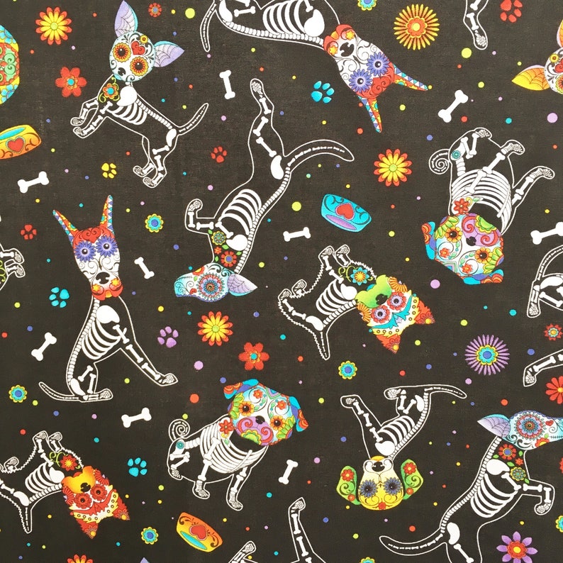 May include: A black fabric with a repeating pattern of colorful, skeleton dogs with sugar skull faces. The dogs are in various poses, including sitting, standing, and running. The background is black with white polka dots and small colorful flowers.