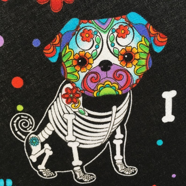 May include: A black and white skeletal pug with a colorful Day of the Dead sugar skull design on its head. The background is black with colorful polka dots.