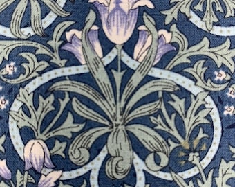 May include: A blue fabric with a repeating pattern of stylized flowers and leaves. The flowers are purple and white, and the leaves are green. The fabric has a textured surface.