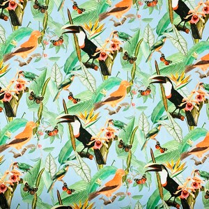 Puede incluir: Un patr&oacute;n tropical colorido con tucanes, mariposas y orqu&iacute;deas sobre un fondo azul claro. El patr&oacute;n es perfecto para telas, papel tapiz u otros proyectos decorativos.