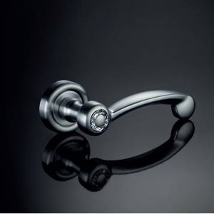 May include: A silver door handle with a round, decorative knob. The handle is curved and has a modern design.