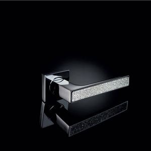 Peut inclure: Une poignée de porte moderne de forme rectangulaire. La poignée est en chrome poli et comporte une longue plaque rectangulaire recouverte de strass scintillants.