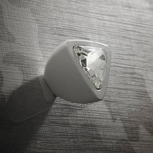 Könnte beinhalten: Weißer dreieckiger Schrankknopf mit einem klaren Kristall-Akzent.