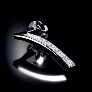 Könnte beinhalten: Ein silberner Türgriff mit einem geschwungenen Design und einer Reihe von klaren Kristallen, die in den Griff eingelassen sind.