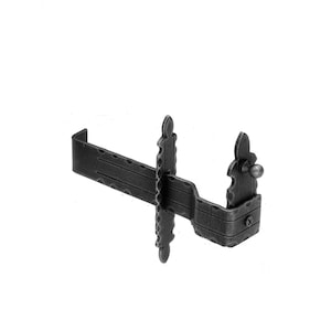 May include: Black metal fireplace grate with decorative scrollwork and a knob on the side.