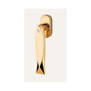May include: Gold-toned door handle shaped like a fish with a small diamond-shaped detail. The handle has a push button on the side.