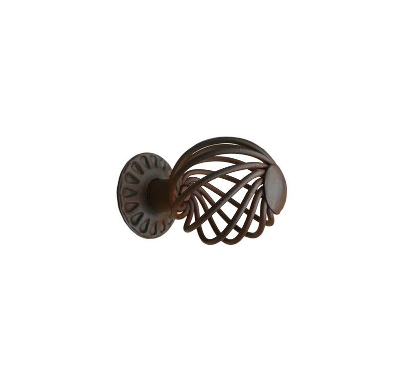 May include: A rusty brown metal cabinet knob with a circular base and a cage-like design.