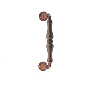 May include: A rusty brown metal door pull handle with a curved design. The handle has a decorative, fluted, cylindrical shape.