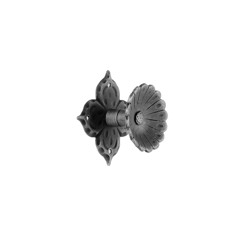 May include: Black metal wall hook with a decorative flower design. The hook has a round, scalloped edge and a smaller flower design in the centre.