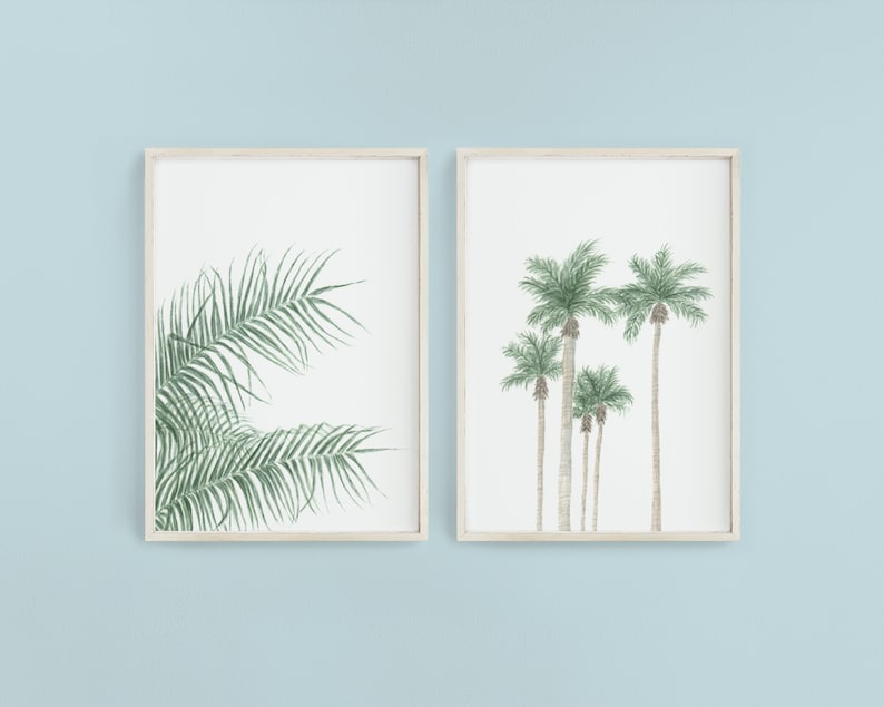 以下が含まれることがあります： 植物のイラストが描かれた額装されたプリントが2枚。左側のプリントは緑色のヤシの葉のクローズアップ。右側のプリントは緑色の葉をつけたヤシの木が5本並んでいる。