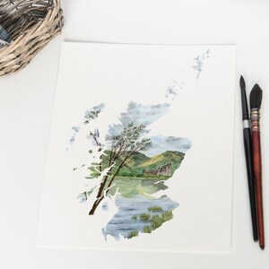 Puede incluir: Una pintura de acuarela de un paisaje escoc&eacute;s, con un castillo y un lago, enmarcado por el contorno del pa&iacute;s de Escocia.