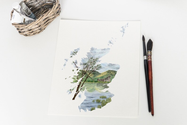 Puede incluir: Una pintura de acuarela de un paisaje escoc&eacute;s, con un castillo y un lago, enmarcado por el contorno del pa&iacute;s de Escocia.
