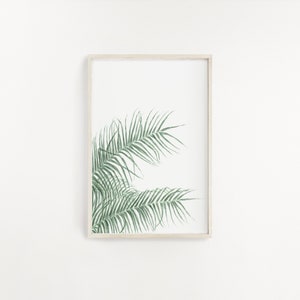 以下が含まれることがあります： 白い背景に緑色のヤシの葉が描かれた額装されたプリント