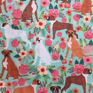 Peut inclure: Un tissu turquoise avec un motif r&eacute;p&eacute;t&eacute; de chiens boxers bruns et blancs et de fleurs roses.