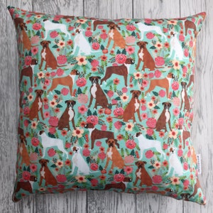 Peut inclure: Un oreiller bleu turquoise avec un motif r&eacute;p&eacute;t&eacute; de boxers bruns et blancs et de fleurs roses, rouges et orange.