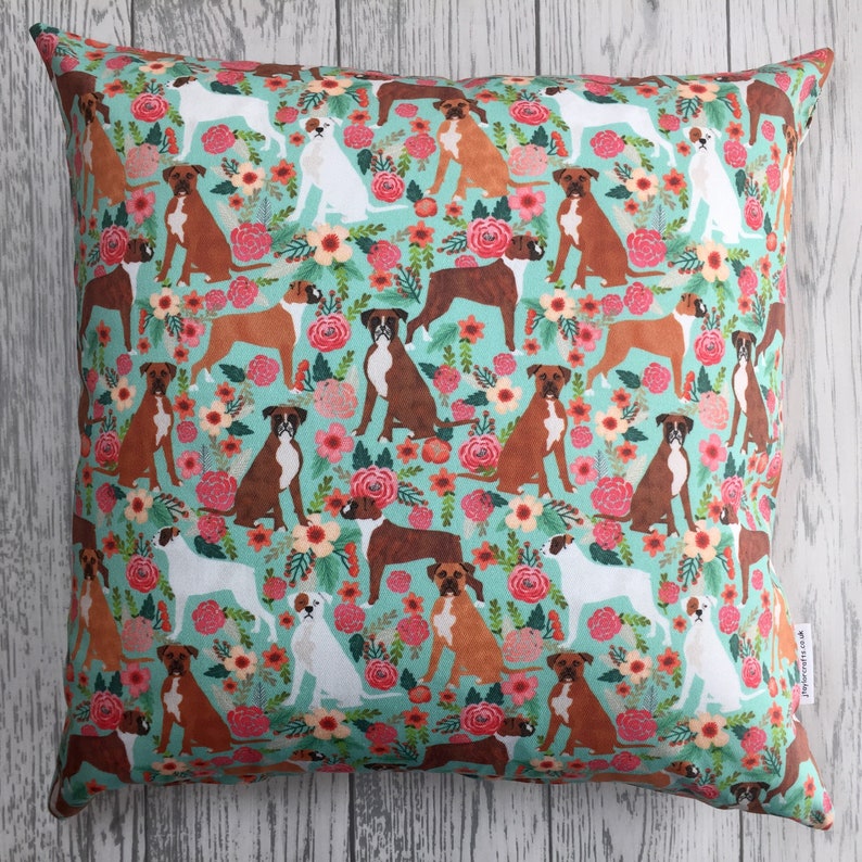 Peut inclure: Un oreiller bleu turquoise avec un motif r&eacute;p&eacute;t&eacute; de boxers bruns et blancs et de fleurs roses, rouges et orange.