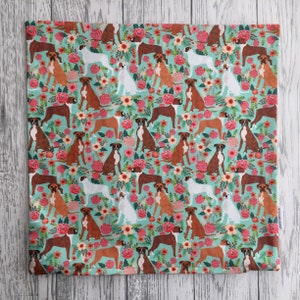Peut inclure: Un tissu turquoise avec un motif r&eacute;p&eacute;t&eacute; de chiens boxers bruns et blancs et de fleurs roses, blanches et vertes.