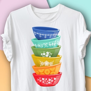 May include: A stack of five colorful bowls with floral patterns. The bowls are stacked from largest to smallest, with the largest bowl being red, the next being yellow, then orange, green, and finally blue.