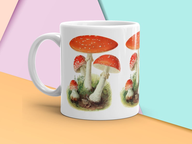 K&ouml;nnte beinhalten: Eine wei&szlig;e Keramik-Tasse mit schwarzem Henkel und dem handgeschriebenen Text "But first, coffee". Die Tasse steht auf einer wei&szlig;en Oberfl&auml;che. F&uuml;r Hei&szlig;getr&auml;nke geeignet.