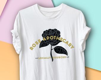Puede incluir: Camiseta blanca con un gráfico de rosa negra y el texto "ROSE APOTHECARY LOCALLY SOURCED".
