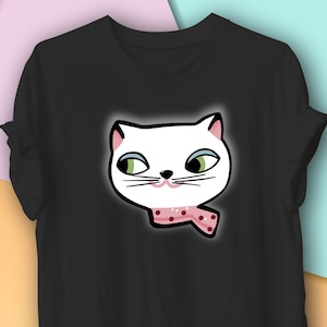 May include: Black t-shirt featuring a cartoon cat face. The white cat has green eyes, a pink nose, and a pink polka-dot scarf. The cat's face is outlined in black, creating a bold graphic design.