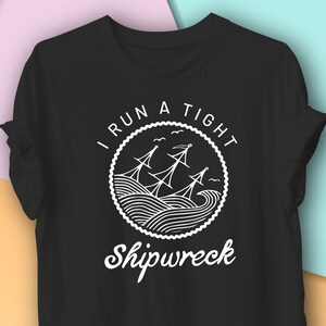 May include: Black t-shirt with a white graphic of a shipwrecked boat in a circle with the text "I run a tight shipwreck".