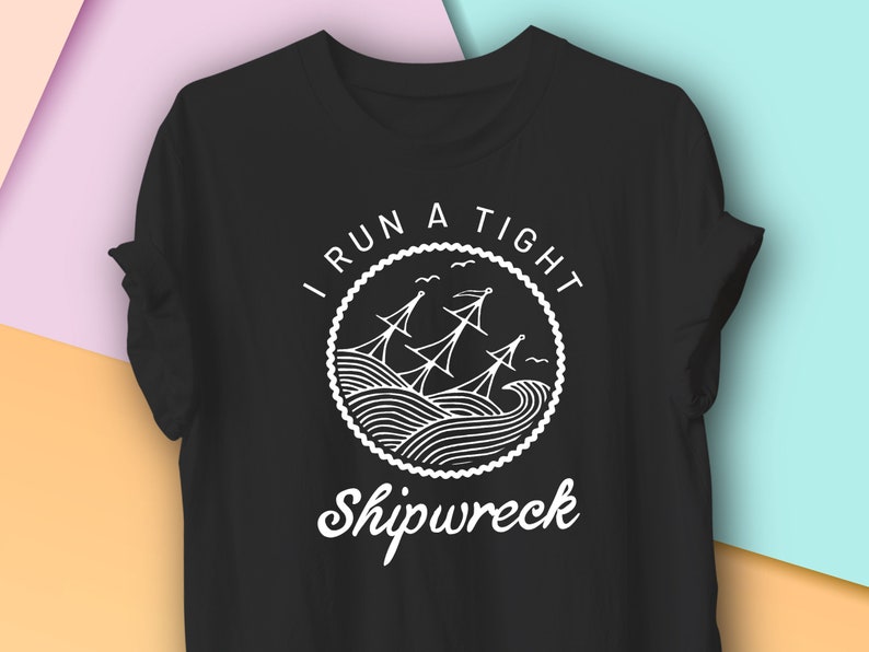 May include: Black t-shirt with a white graphic of a shipwrecked boat in a circle with the text "I run a tight shipwreck".