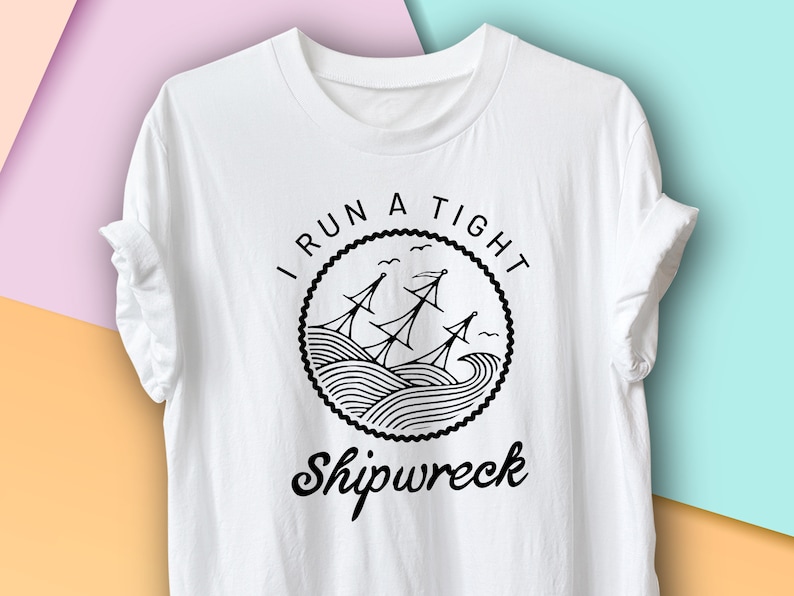 May include: White t-shirt with a black graphic design that says "I run a tight shipwreck". The graphic features a ship with sails and waves.