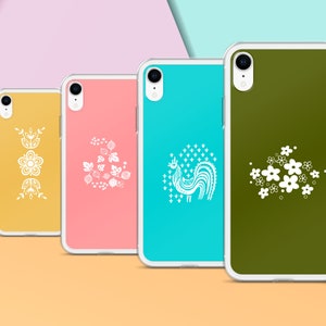 Pu&ograve; includere: Quattro custodie per telefono con diversi design. Le custodie sono trasparenti e hanno un design bianco su sfondo giallo, rosa, blu e verde. I design includono un motivo floreale, un motivo di bacche, un motivo di gallo e un motivo di fiori.