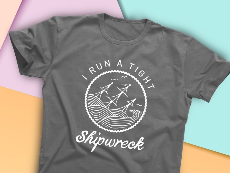 May include: Gray t-shirt with a white graphic design of a ship in a circle with the text "I run a tight shipwreck".