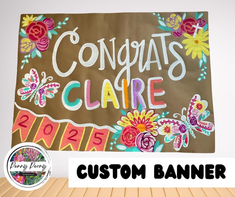 May include: A custom banner with the words "Congrats Claire" in white, with colorful letters. The banner is decorated with floral and butterfly designs. The year "2025" is also displayed. The banner is brown with a white border.