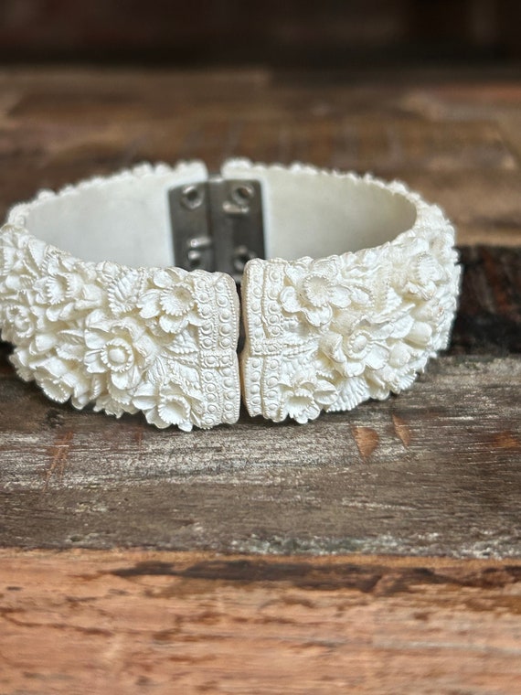 Carved floral white celluloid? hinged cuff bracele