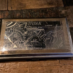 Vintage silver tone and gold tone cigarette case etched with a map of India on one side and an image of the Taj Mahal on the other