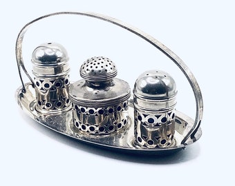 May include: Silver salt and pepper shakers with a decorative design, set on a silver tray with a handle.