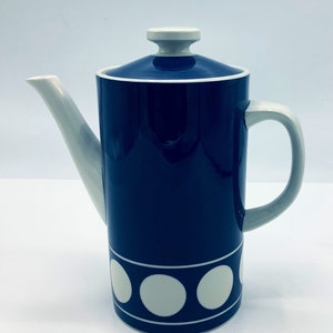 Może przedstawiać: Niebieski ceramiczny dzbanek do kawy z białą pokrywką i białymi kółkami wokół podstawy.