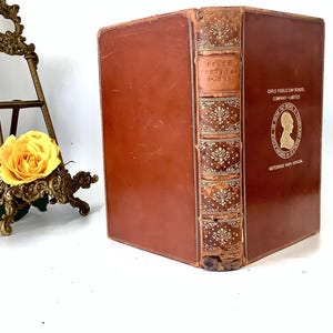 May include: A brown leather-bound book with gold lettering and decorative accents. The title on the spine reads "Keats Poetical Works". The book is from the Girls Public Day School Company Limited, Gateshead High School.