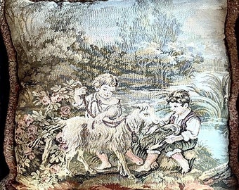 May include: A tapestry pillow featuring a scene of two children with a dog in a forest setting. The pillow has a brown and beige border.
