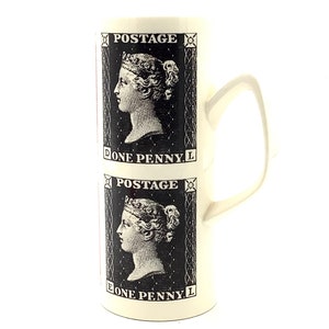 Puede incluir: Taza de cerámica blanca con una imagen en blanco y negro de un sello de correos con el perfil de una mujer y el texto "POSTAGE ONE PENNY" repetido dos veces.