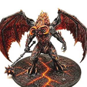 Puede incluir: Figura detallada de una criatura demoníaca con cabello y cuernos de fuego, de pie sobre una base circular. La figura tiene grandes alas texturizadas y sostiene una maza con púas. La paleta de colores incluye tonos de rojo, naranja y negro.