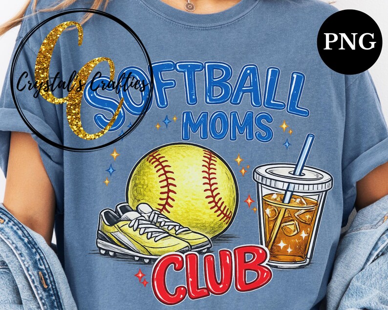 May include: Blue t-shirt with a softball-themed graphic. The design includes a yellow softball, cleats, a drink with ice, and the words "SOFTBALL MOMS CLUB" in blue and red. The shirt has a relaxed fit.