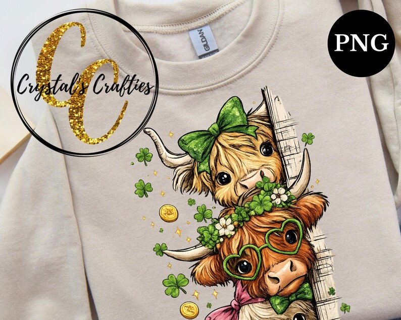 May include: A beige sweatshirt with a St. Patrick's Day theme. The design shows two cartoon Highland cows with shamrocks, gold coins, and green bows. The text "Crystal's Crafties" is in a gold glitter circle.