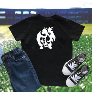 May include: Black t-shirt with a white silhouette of a dragon made up of smaller dragons.