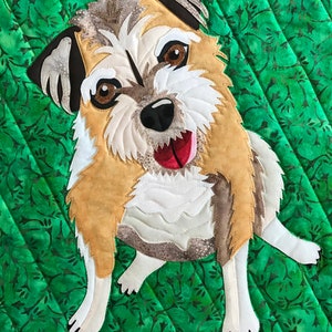 May include: A brown and white dog with a black nose and brown eyes is sitting on a green background. The dog has a white chest and a white patch on its forehead. The dog is looking at the camera with its tongue sticking out.