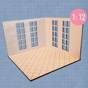 May include: A miniature dollhouse room with three window cutouts on two walls. The floor has a diamond pattern. The scale is 1:12, indicated by text in a pink circle. The room is made of light brown wood.