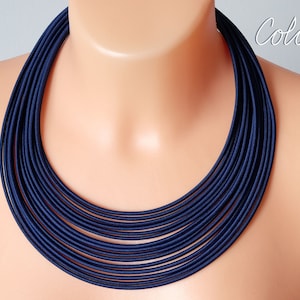 Op de afbeelding: Een meerrijige ketting van donkerblauwe stof. De ketting is gelaagd en creëert een dikke, stoere look.