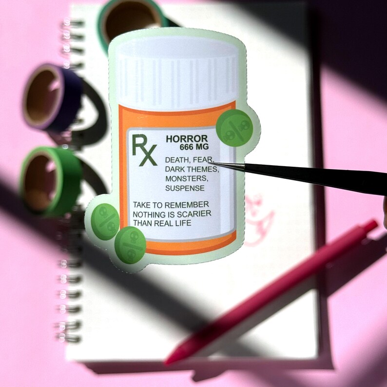 The image shows a sticker shaped like an orange and white medical pill bottle. The bottle is for the drama genre in books, movies, television, and other forms of media. The design is accented with bright green and pills with drama skulls on it. The test reads- Horror 666mg. 
Death, fear, dark themes, monsters, suspense. 
Take to remember nothing is scarier than real life.