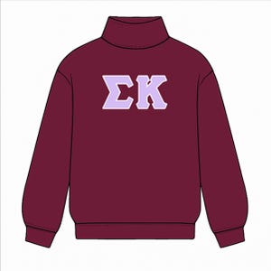 May include: A maroon turtleneck sweatshirt with the Greek letters Σ and K in a light purple color. The sweatshirt has long sleeves and a ribbed collar.