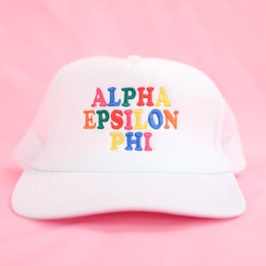 May include: White trucker hat with a rainbow embroidered logo that says "ALPHA EPSILON PHI"